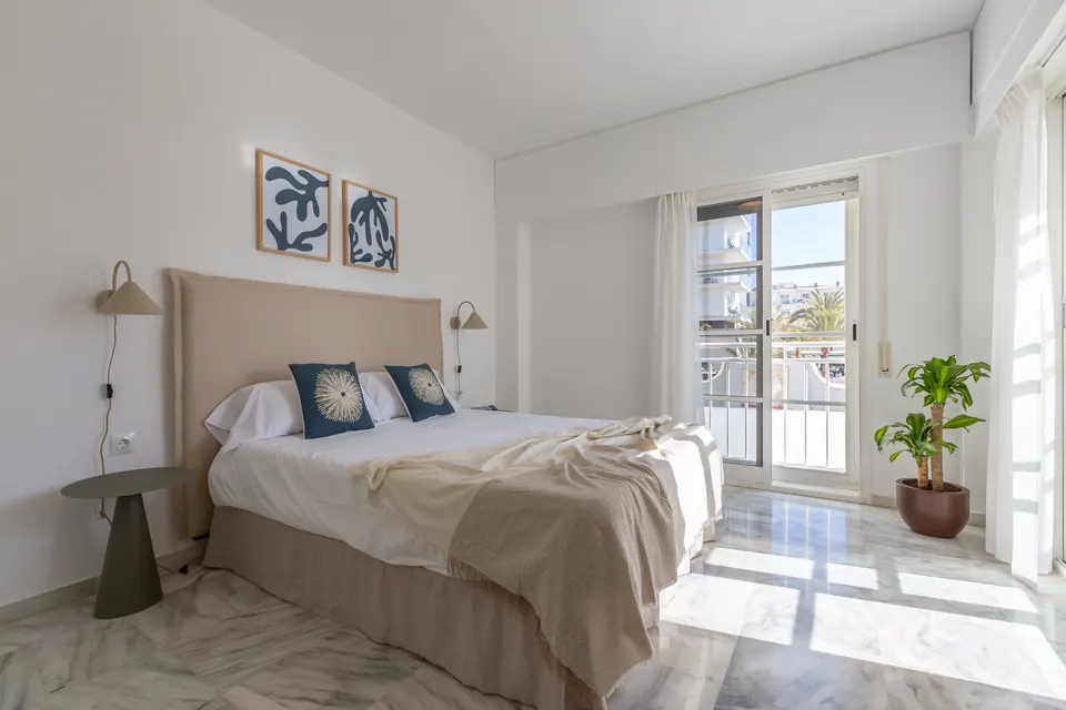 Dormitorio principal con cama doble y acceso a la terraza