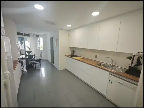 Cocina con encimera de madera y muebles blancos